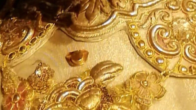 Un pequeño tricornio de oro prendido en la saya de la Macarena estos días