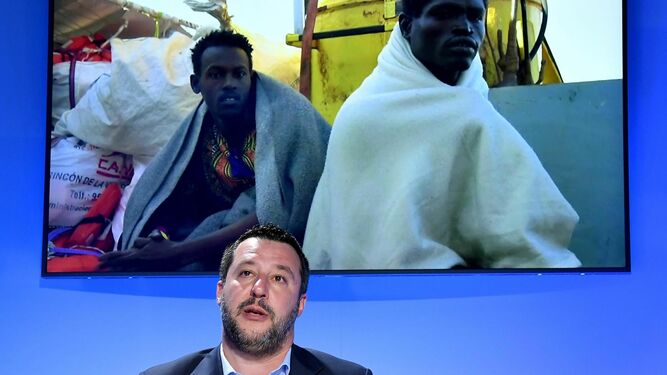 Salvini, durante su intervención este lunes en un foro, con una imagen de inmigrantes a su espalda.