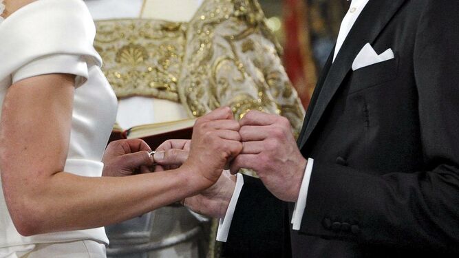 Los contrayentes se colocan las alianzas en una boda religiosa.