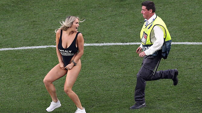 Un agente de seguridad de la UEFA persigue a la joven.