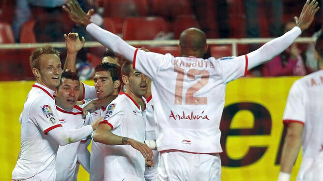 Kanoute y Rakitic, junto a otros compañeros, celebrando un gol de Reyes.
