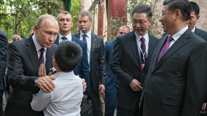 Vladimir Putin saluda a un niño durante su visita al zoo de Moscú junto al presidente chino, Xi Jinping.