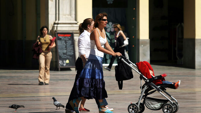 Una mujer empuja el carrito de su bebé.