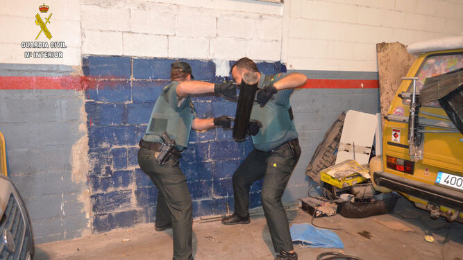 Agentes de la Guardia Civil derribando un tabique para localizar la droga
