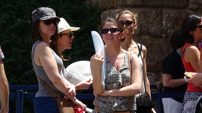 Turistas se abanican mientras hacen cola para visitar el Real Alcázar.