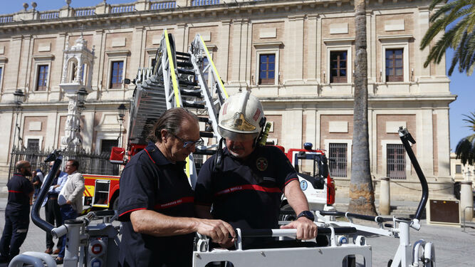 Dos bomberos examinan el nuevo vehículo adquirido por el Ayuntamiento.