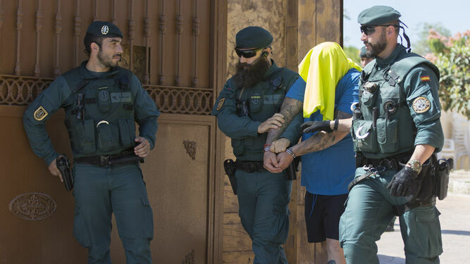 Tres guardias civiles sacan a Ginés de su casa de Coria del Río, en verano de 2019.
