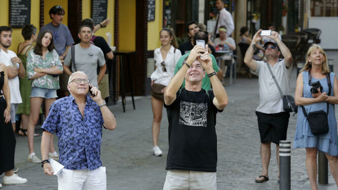 Turistas hacen fotos de monumentos históricos en Sevilla