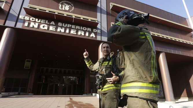 Dos bomberos dialogan tras la intervención en el incendio de la Escuela Superior de Ingeniería.