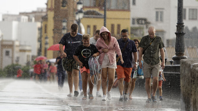 Turistas mojándose en uno de los pocos días de lluvia de septiembre en Sevilla, a mediados de mes.