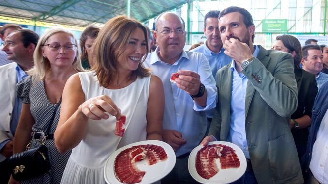 Pablo Casado y el líder del PP extremeño, José Antonio Monago, degustan ayer jamón en la Feria Ganadera de Zafra.