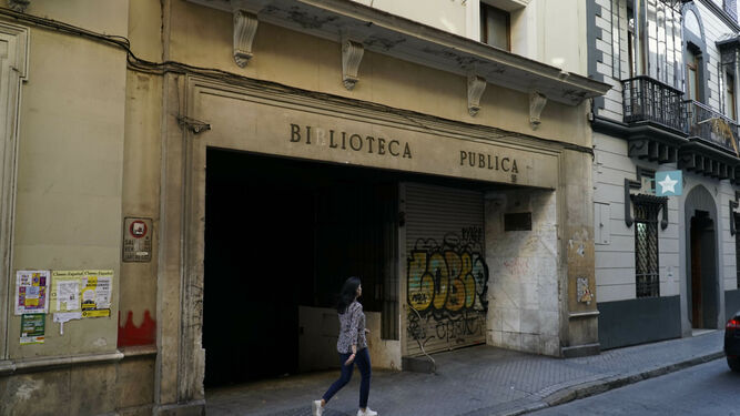 Una mujer pasa por la entrada principal de la antigua Biblioteca municipal de la calle Alfonso XII.
