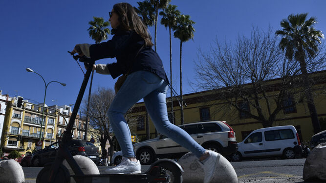 Una usuaria de patinetes eléctricos circula por el carril bici en Sevilla.