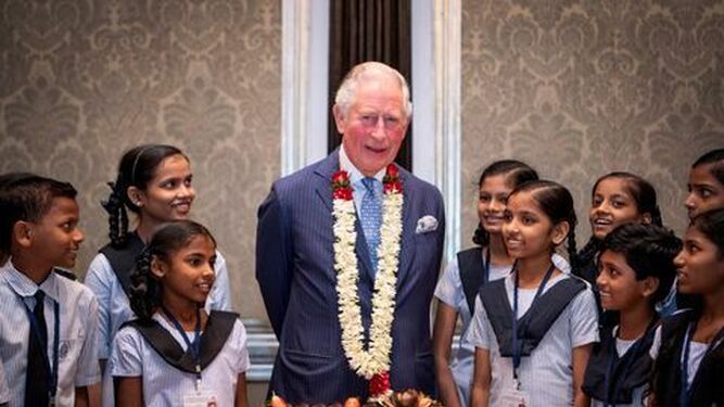 El príncipe Carlos, celebrando con una tarta y rodeado de niñas indias.