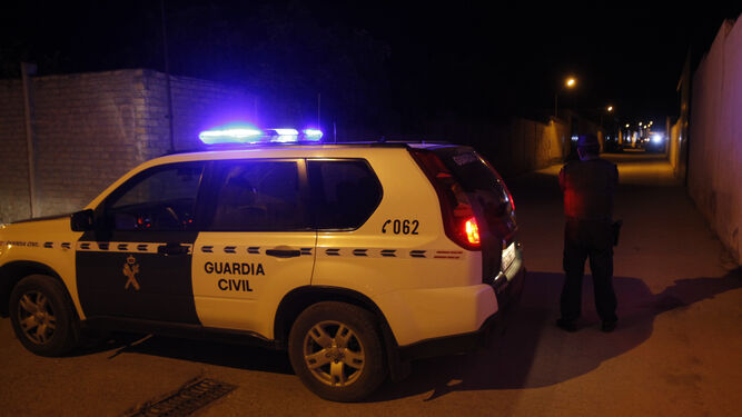 Un agente de la Guardia Civil impide el acceso al lugar del tiroteo, anoche en La Puebla de Cazalla.