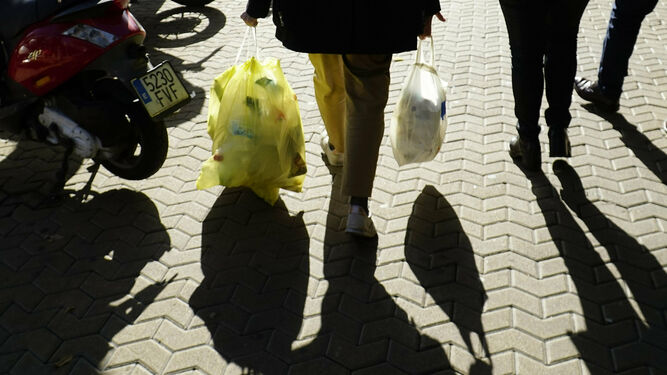 Un ciudadano con una bolsa de basura con envases y otros restos, en la ciudad de Sevilla.