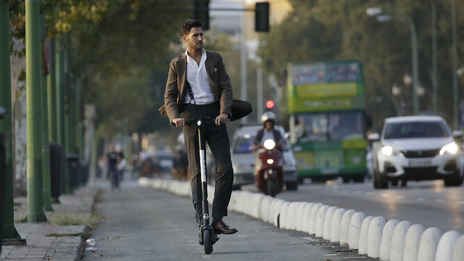 Un usuario de patinete por el carril bici de la ciudad.