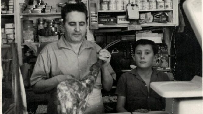 Román Castro corta jamón sin ayuda de caballete en presencia de su hijo Antonio (1961)