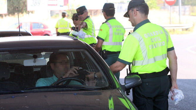 Un guardia civil realiza a un conductor un control de alcoholemia.