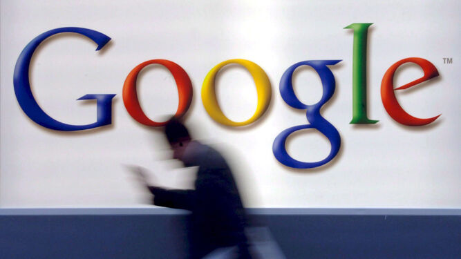 Un hombre pasa bajo el logotipo de Google en una oficina de la empresa.