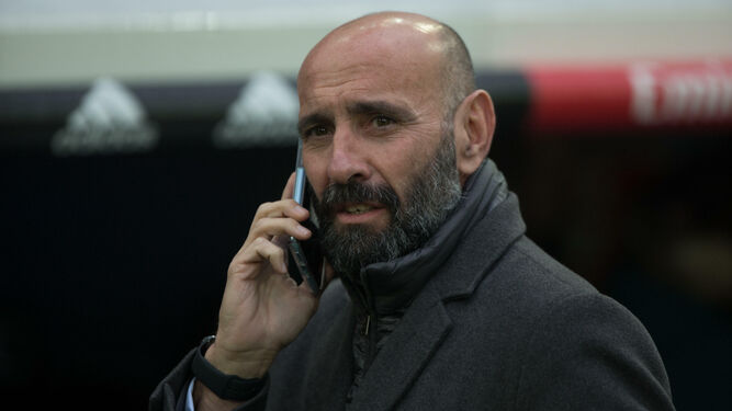 Monchi habla por teléfono en la zona de banquillos antes del Real Madrid-Sevilla.