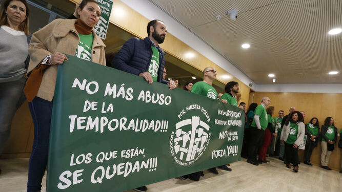 Interinos de la Diputación de Sevilla exhibiendo pancartas durante un pleno.