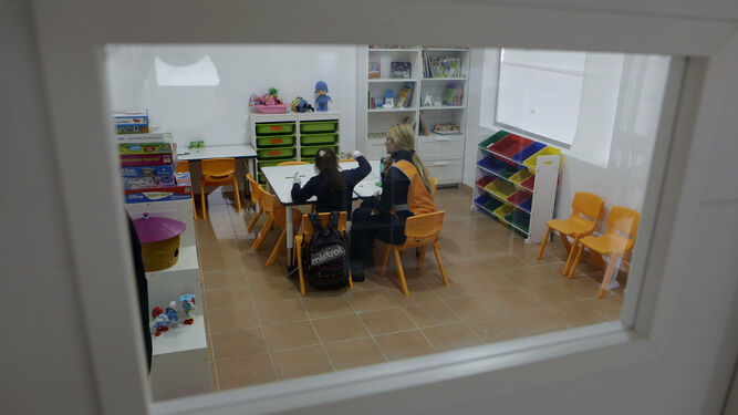Una educadora junto a una menor en una de las salas de estudio del centro de día para menores de Amate.