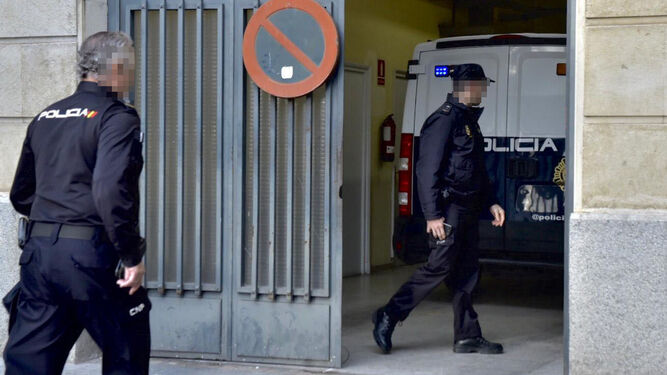 Dos policías nacionales junto al furgón a su llegada a la Audiencia de Sevilla.