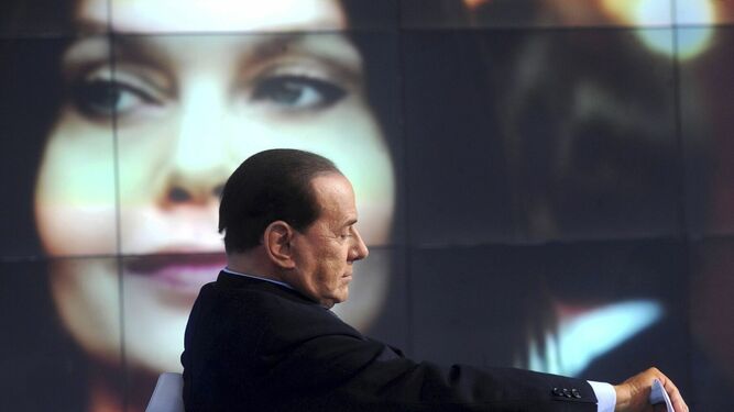 Berlusconi, con una imagen de su ex esposa de fondo, en un programa de la televisión italiana.