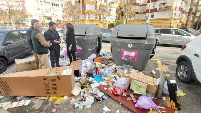 El portavoz del PP en Sevilla, Beltrán Pérez, rodeado de basura junto a varios contenedores en la zona.