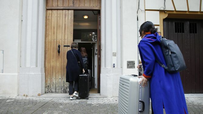 Varios turistas entran en una vivienda turística del centro de Sevilla.