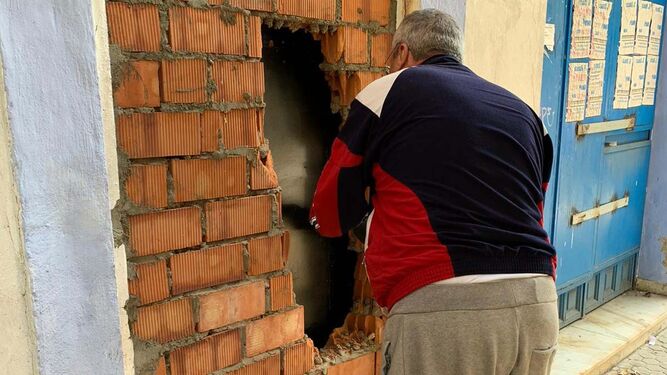 Un vecino procede al tapiado de la puerta de acceso a la vivienda ocupada en Nervión.