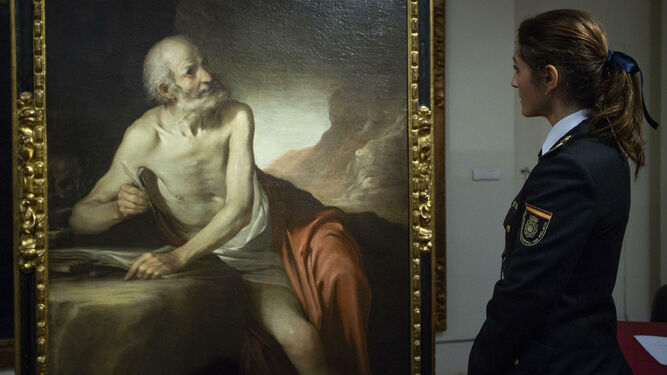 Una agente de la Policía Nacional mira el cuadro recuperado, este miércoles en el Museo de Bellas Artes.