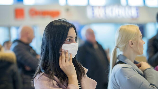 Una turista con mascarilla en un aeropuerto.