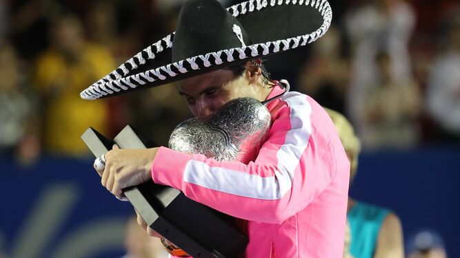 Rafa Nadal muerde el trofeo de campeón en Acapulco.