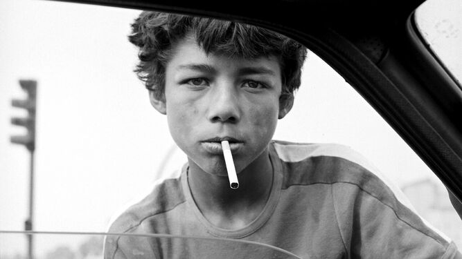 Un niño vende tabaco en un semáforo.