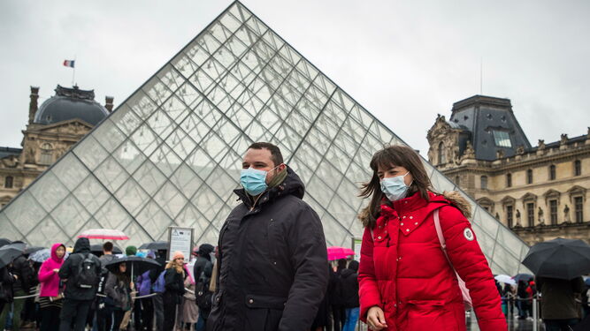 Un par de turistas en las afueras del Louvre