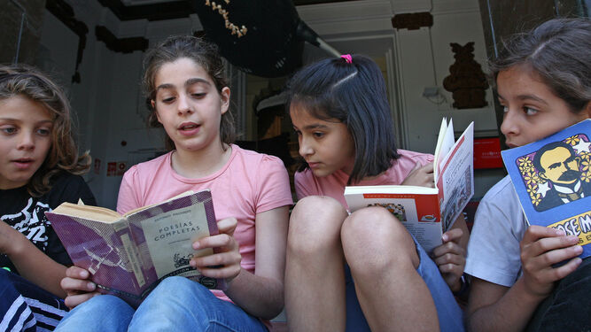 Un grupo de niñas lee libros de diversas temáticas.