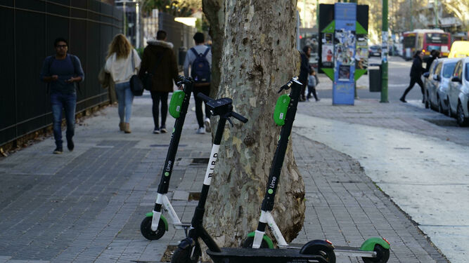 Varios patinetes aparcados en la vía pública en Sevilla.