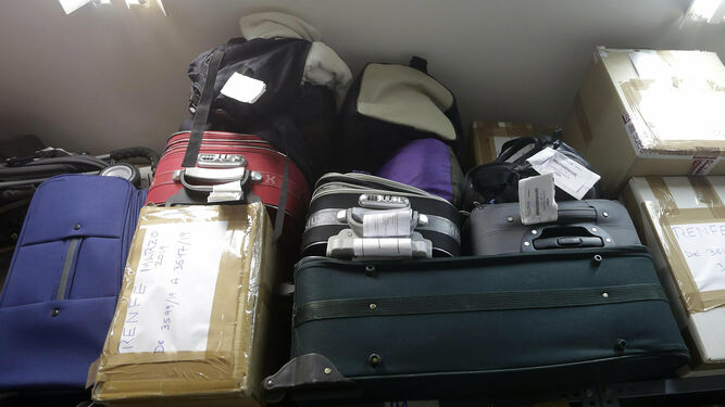 Varias maletas apiladas en las estanterías del almacén.