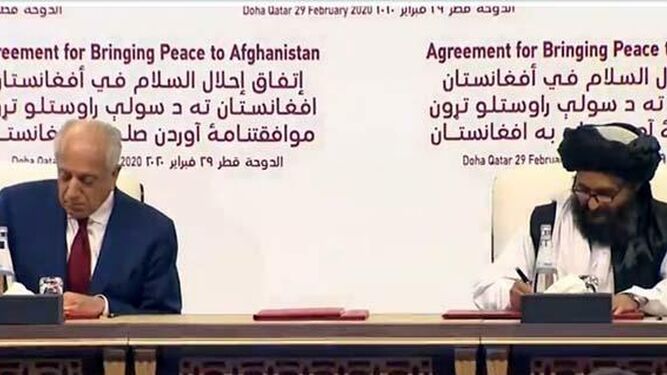 El representante especial de EEUU para la paz, Zalmay Khalilzad, y, el líder talibán mulá Abdul Ghani Baradar, firman el acuerdo en Qatar.