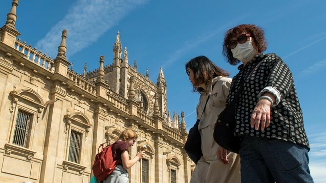 Turistas  asiáticas caminan por Sevilla.