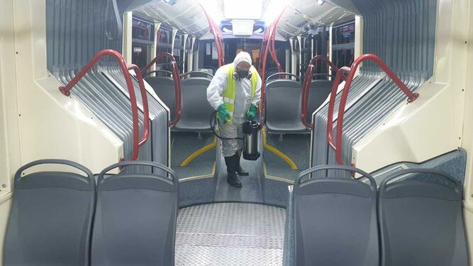 Un operario limpia uno de los autobuses de Tussam.
