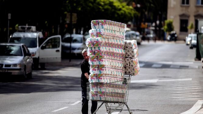Un comerciante traslada en un carro un cargamento de papel higiénico