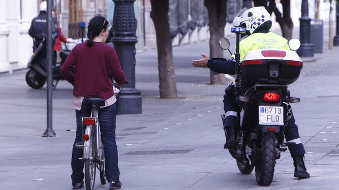 La Policía Local da indicaciones a una ciclista en la avenida de la Constitución.