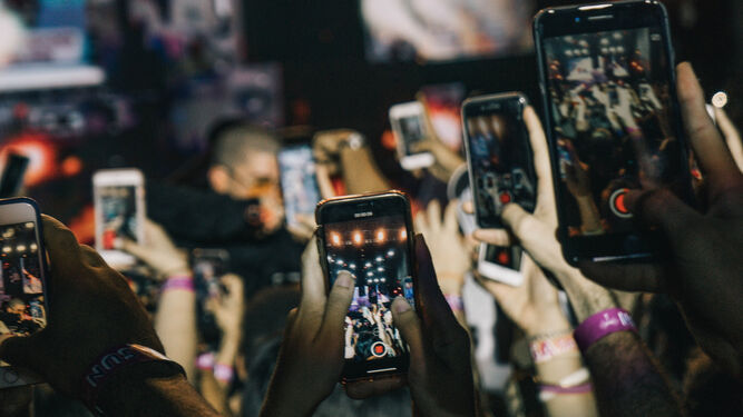 Una multitud, con sus móviles en la mano.