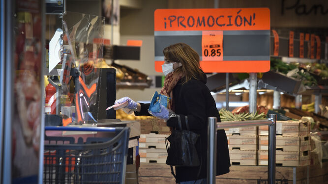 Una mujer enseña un producto en un supermercado.