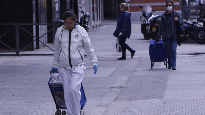 Varias personas paseando por las calles de Sevilla.