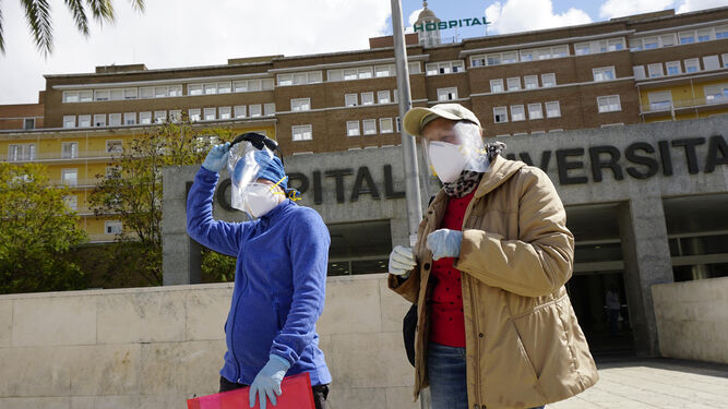 Dos mujeres con guantes y mascarillas abandonan el Hospital Virgen del Rocío.