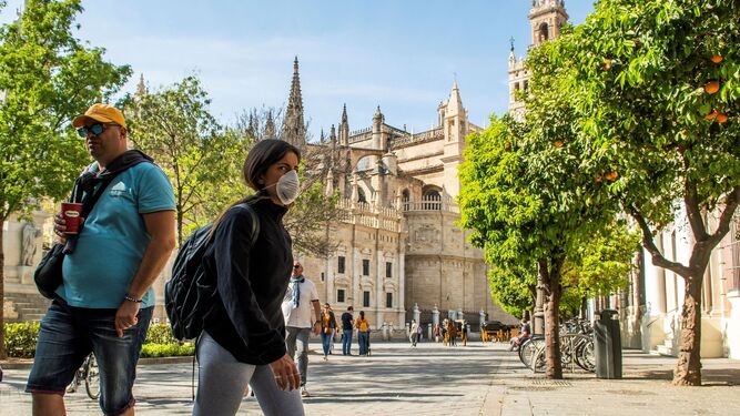 Turistas, con mascarilla, paseando por Sevilla.